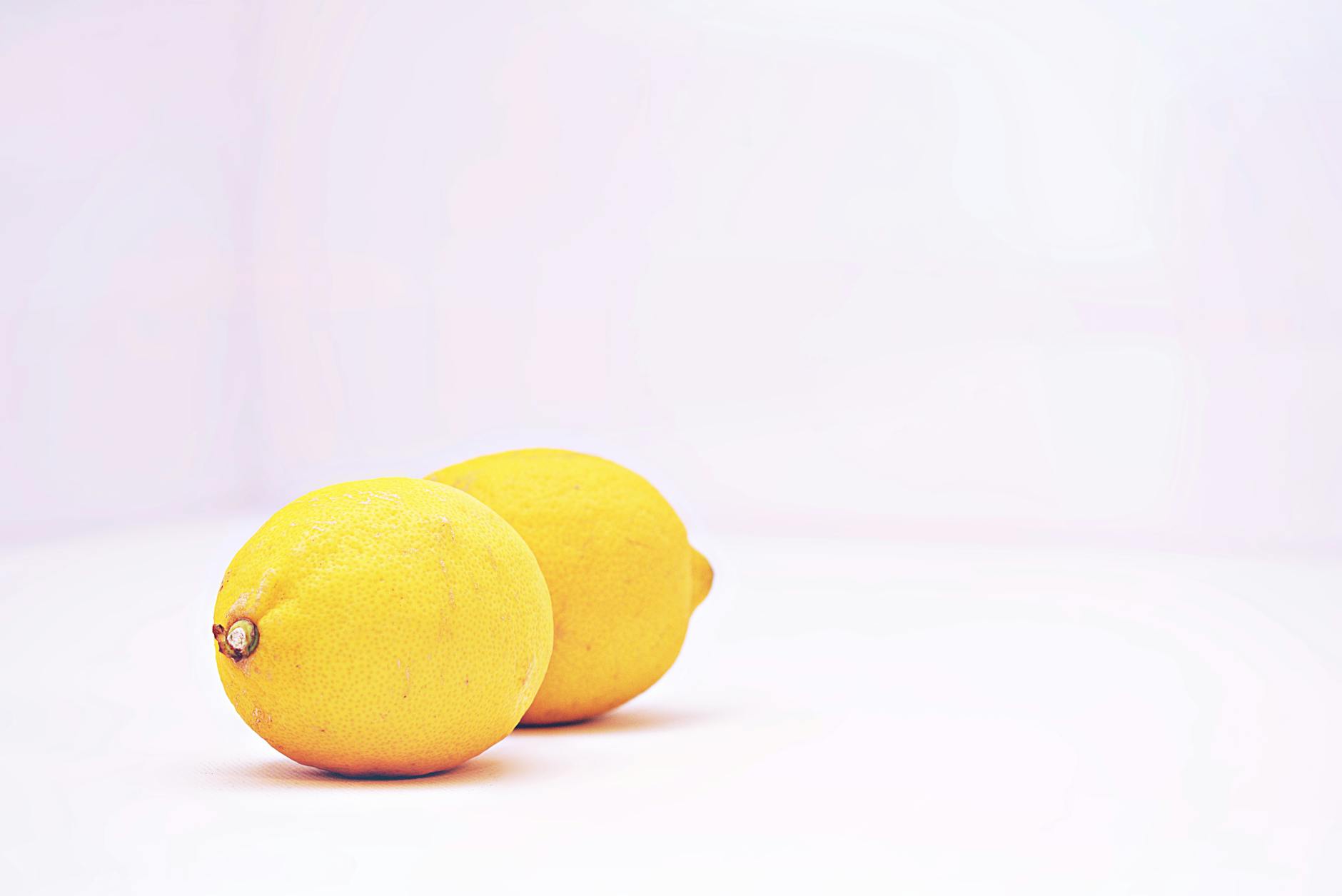 Hand holding an orange vibrator against a purple backdrop, showcasing modern sensuality