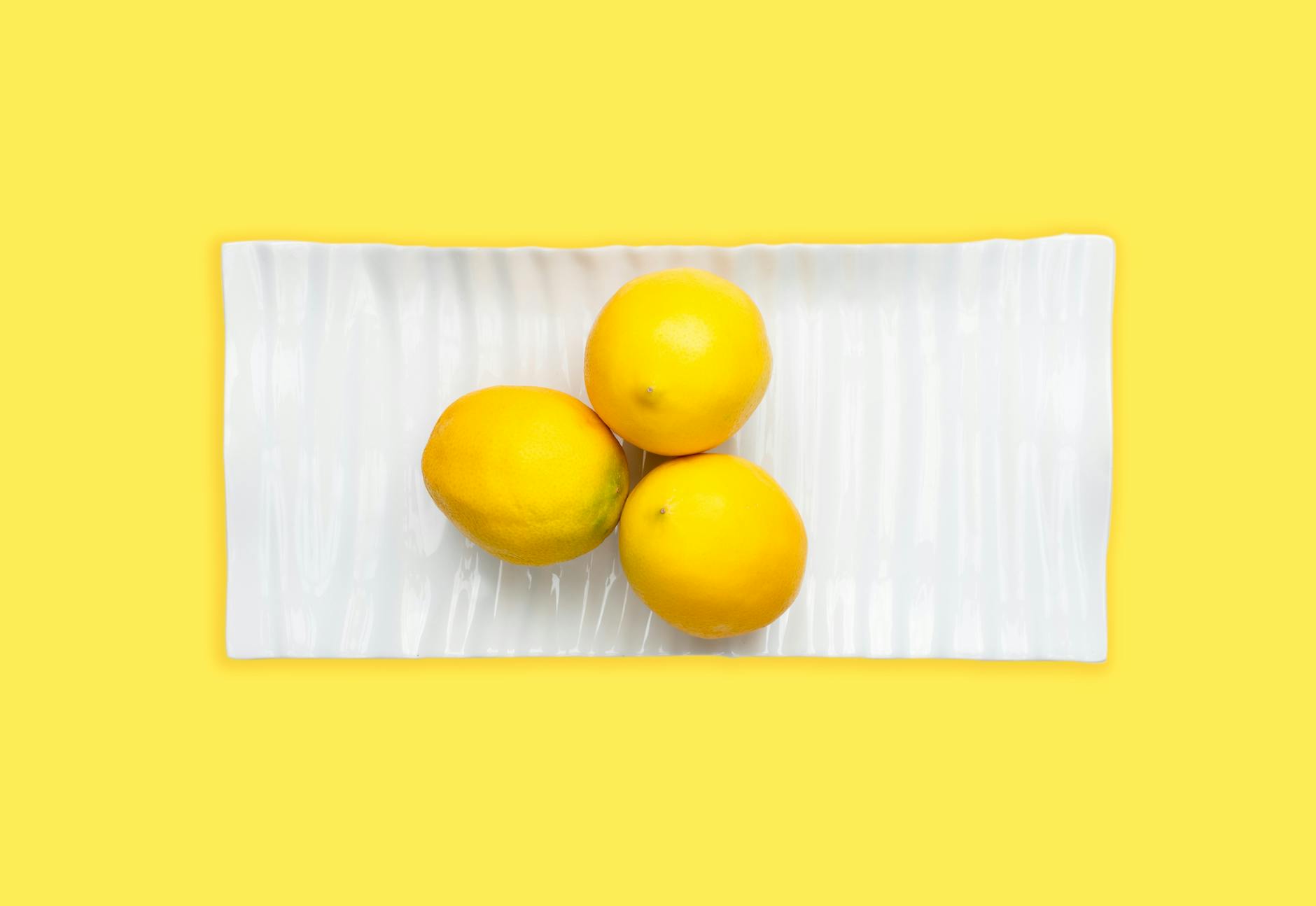 Bright yellow lemons arranged on a pastel green background, symbolizing measured intensity and gentle pleasure.