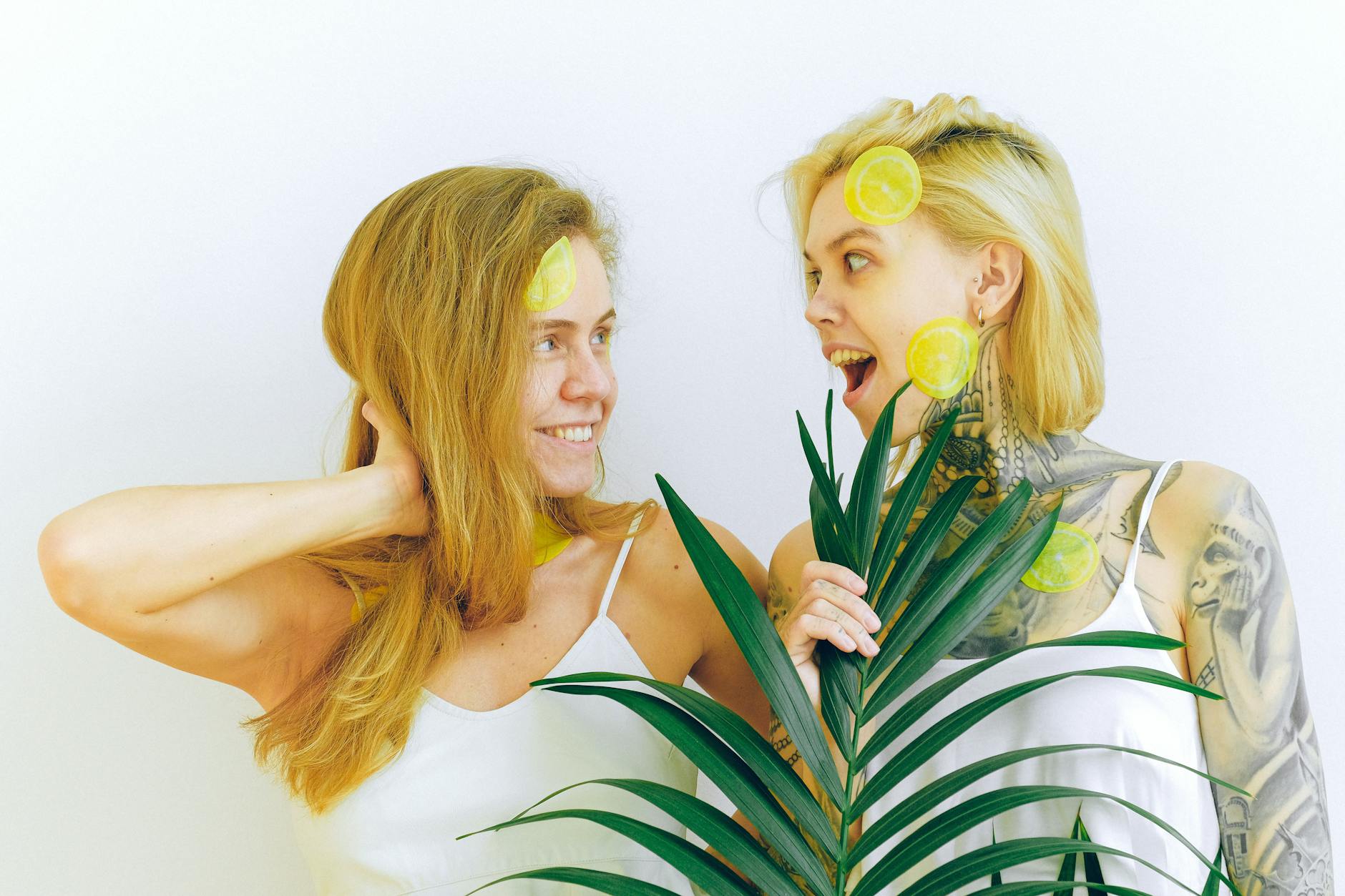 Two women smiling and enjoying time together, expressing joy and comfort in a relaxed setting.