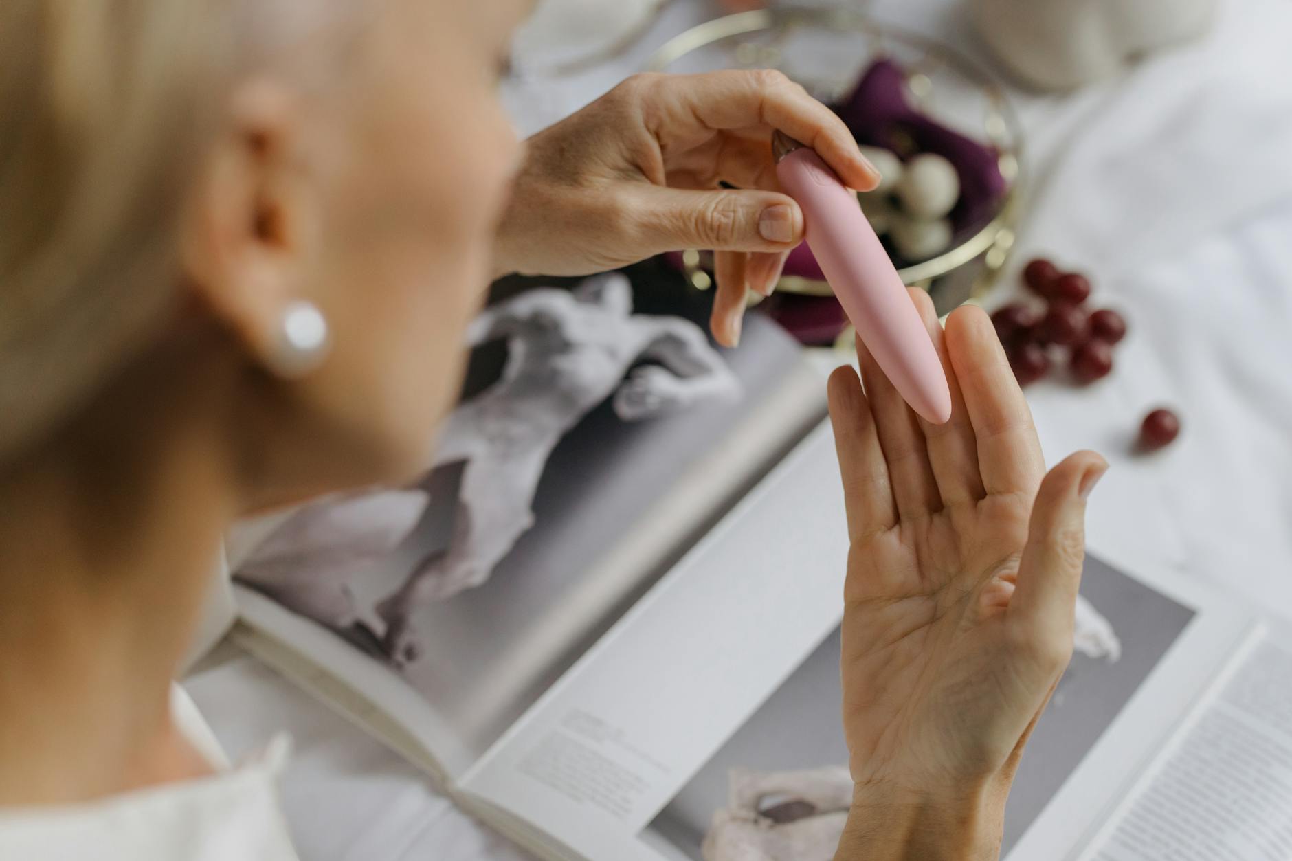 A hand holding a pink vibrator, emphasizing intimate pleasure during recovery and healing.