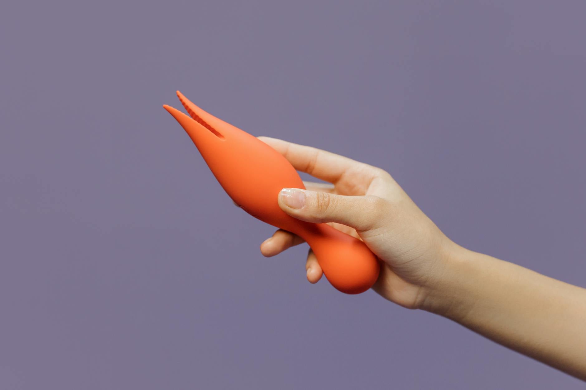 A hand holding a lemon-colored vibrator against a minimalistic purple backdrop, symbolizing gentle intimate recovery.