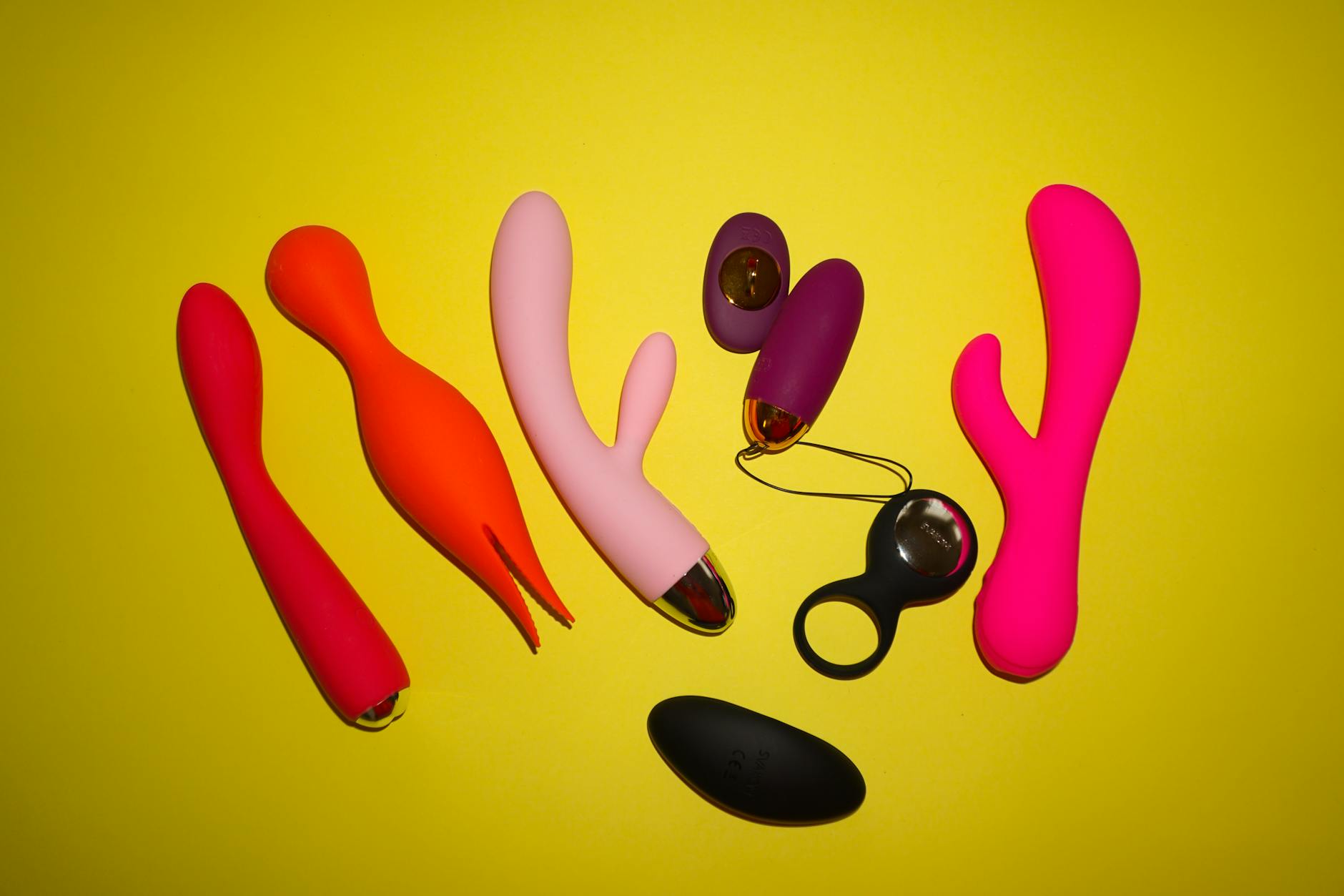 Colorful clitoral vibrators arranged on a bright studio background, showcasing shapes and textures